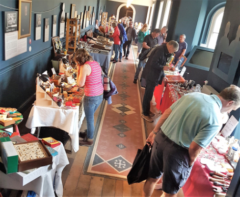 Visitors looking at various antiques stalls in the Long Gallery