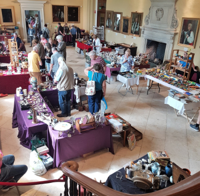 Visitors browsing antiques stalls in Hartlebury Castle's Medieval Great Hall