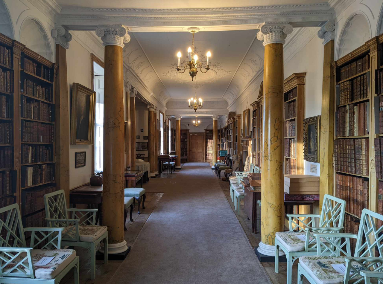 The long corridor of the Hurd Library at Hartlebury Castle, featuring columns and bookshelves