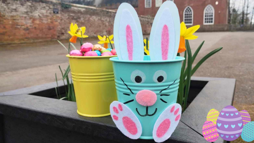 A pot of chocolate eggs and an Easter bunny pot with ears, face and feet outside Hartlebury Castle