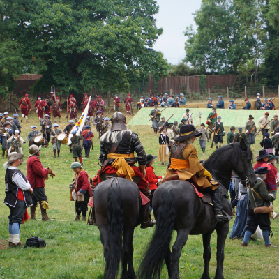 Re-enactment of a Civil War battle on a field, with hundreds of troops and two soldiers on horseback in the foreground