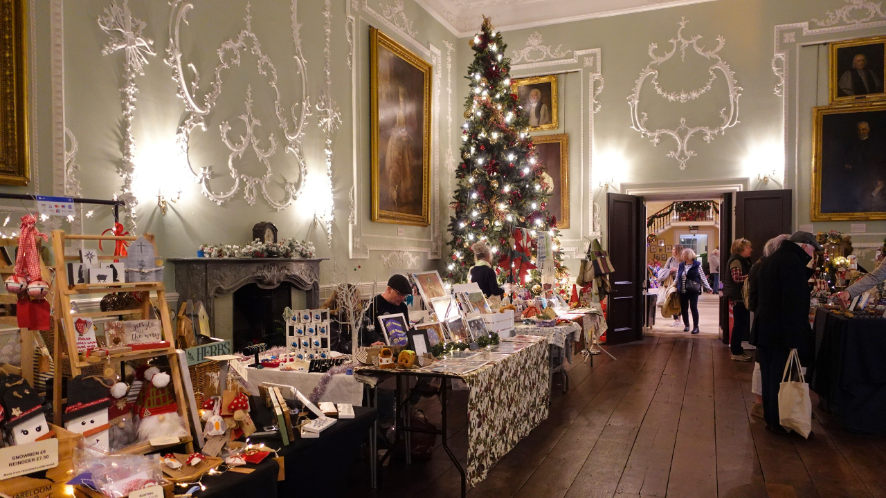 The Castle Saloon filled with craft stalls and dressed for Christmas, including a tall, decorated Christmas tree
