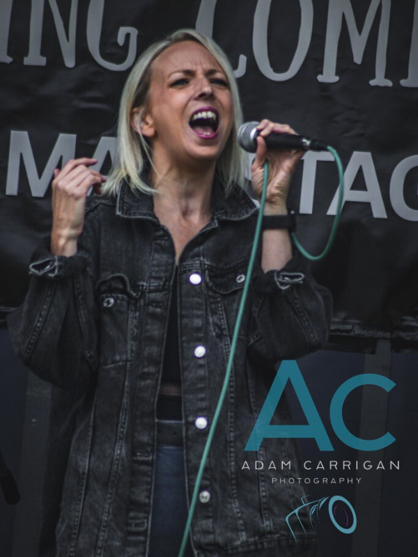 Photo of female singer performing with an Adam Carrigan Photography watermark