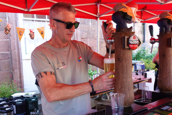 Man with sunglasses pulling draft beer