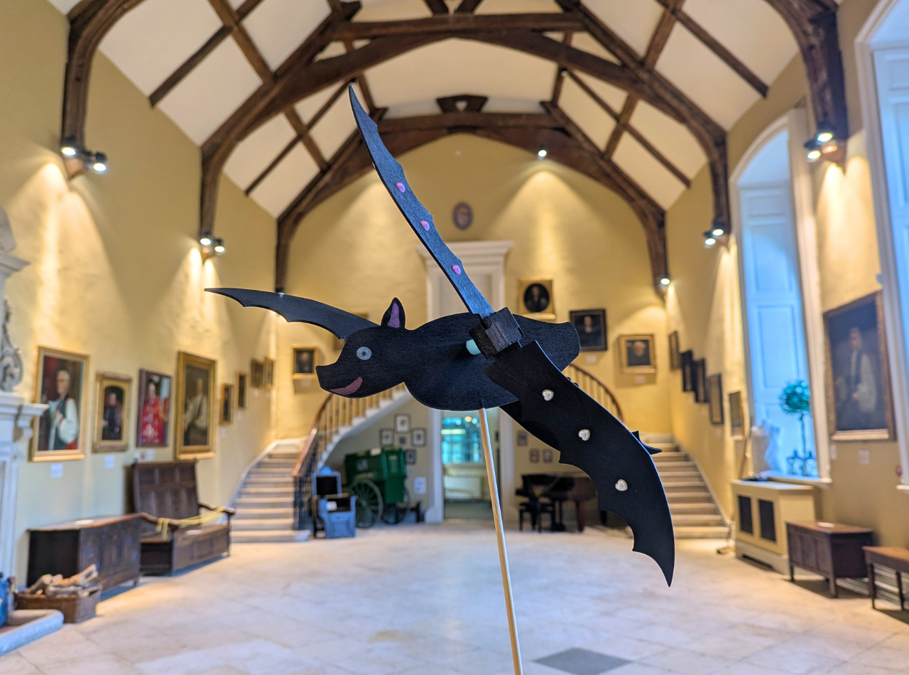 Bat windmill on a wooden stick in the Castle's Great Hall, with its wooden beamed ceiling and many portraits